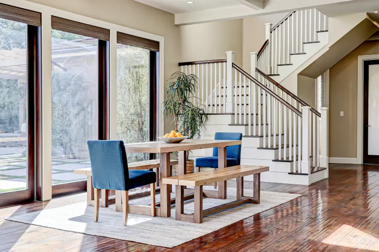Elegant dining room with modern staircase and warm lighting